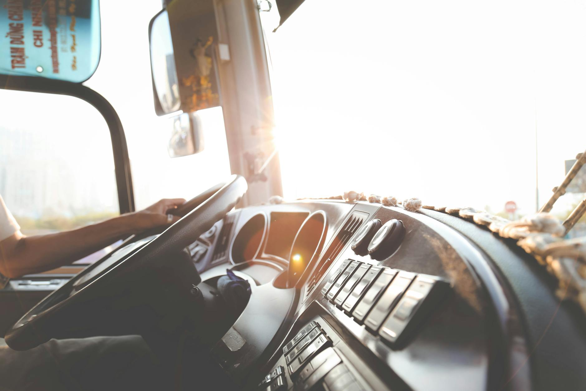 Kierowca autobusu skoncentrowany na jeździe po słonecznych ulicach miasta