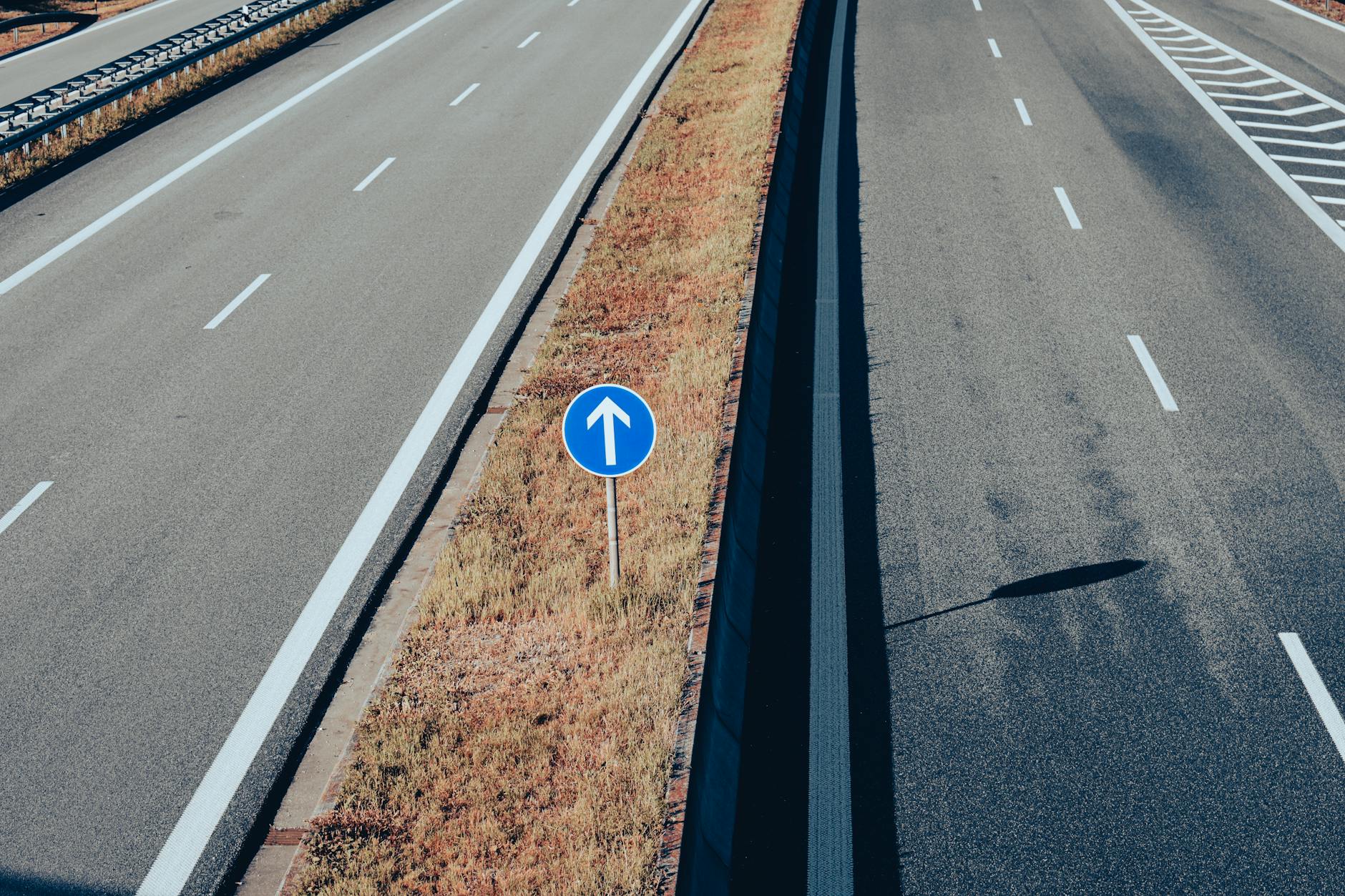 Pusty odcinek autostrady z widocznym znakiem kierunku jazdy z góry