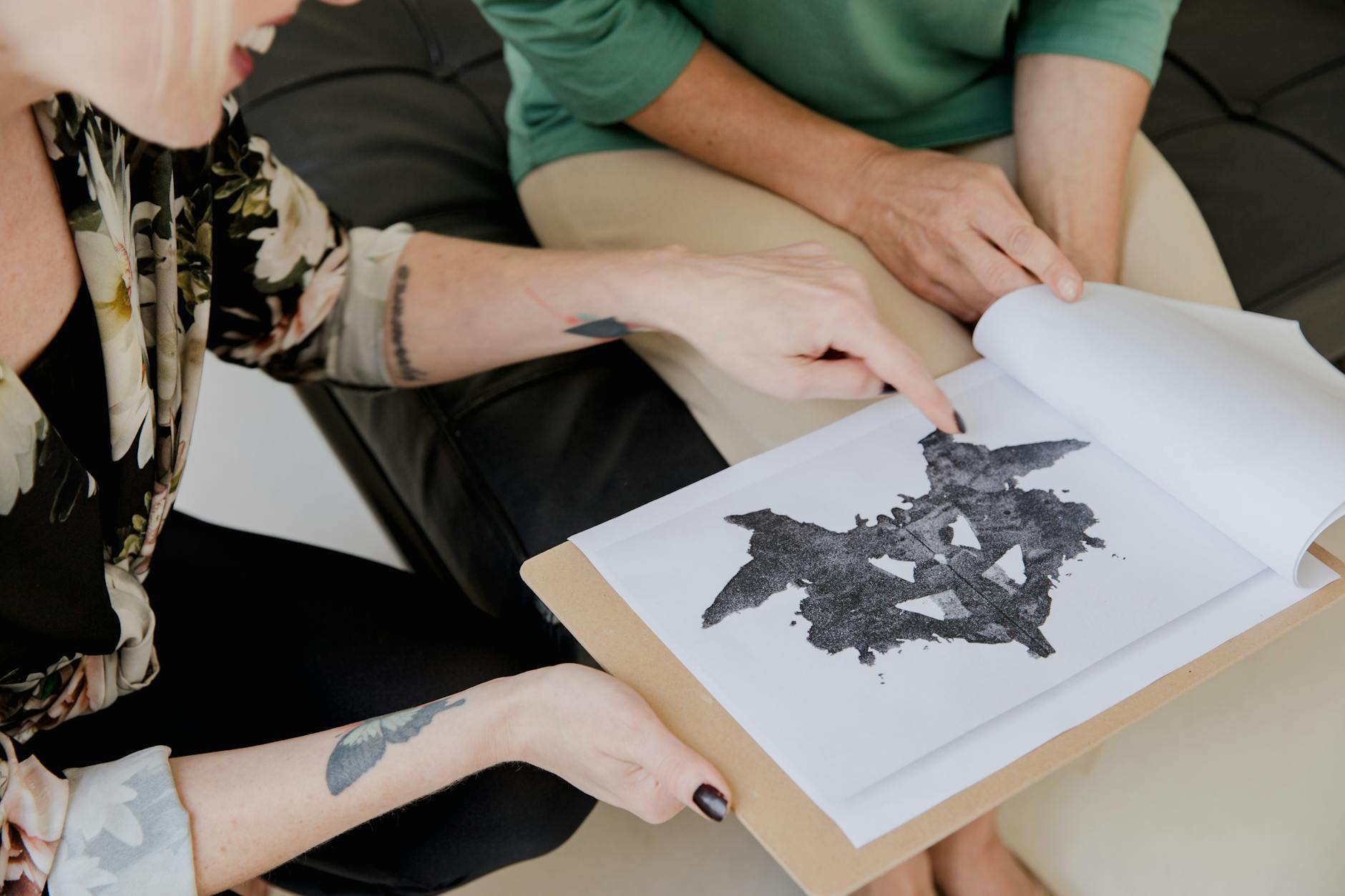 Dwóch dorosłych analizuje test Rorschacha w gabinecie psychologicznym